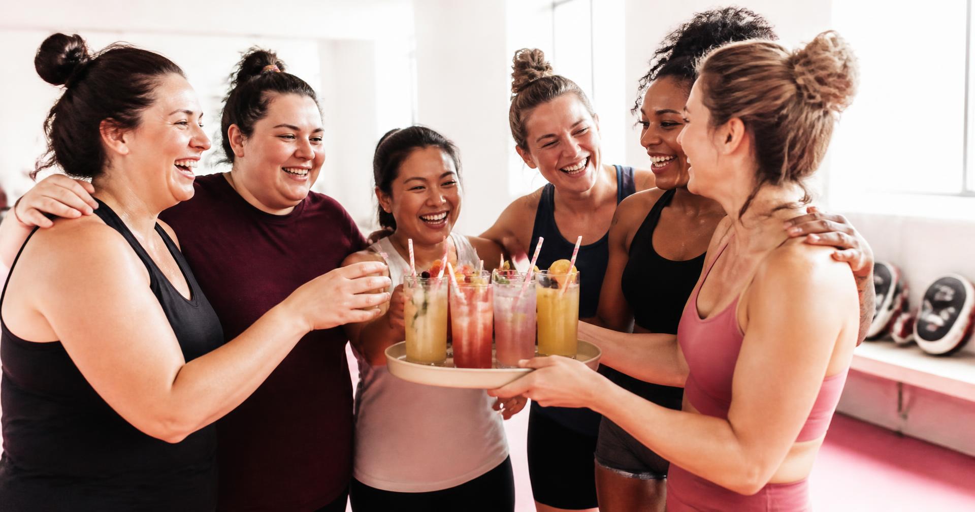 Moms laughing together over a tray of mocktails after class